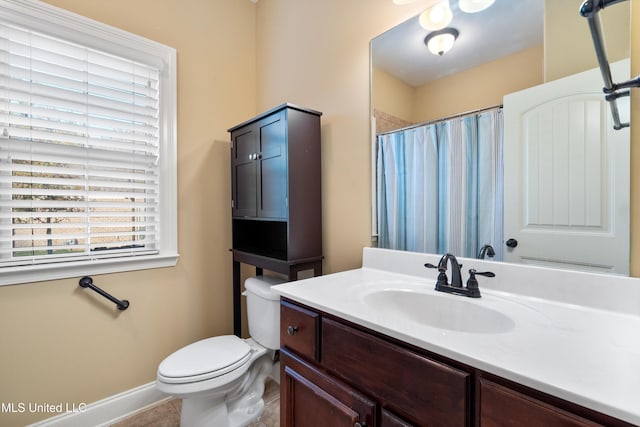 bathroom with tile patterned flooring, vanity, toilet, and walk in shower