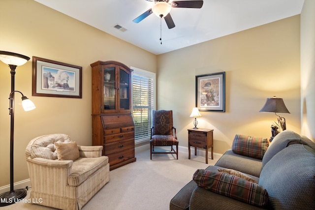 living area with ceiling fan and light colored carpet