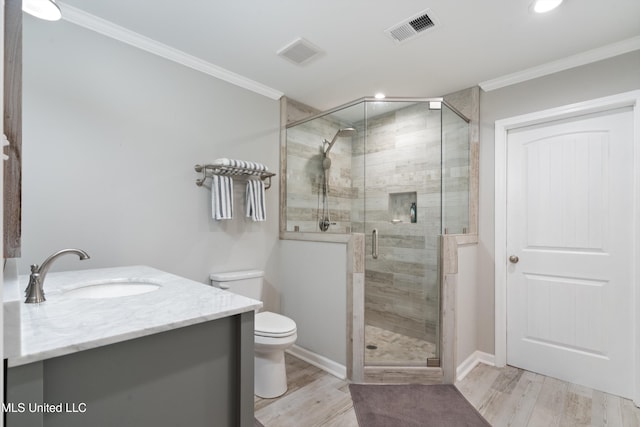 bathroom with vanity, hardwood / wood-style flooring, toilet, ornamental molding, and a shower with shower door