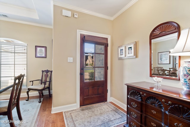 foyer with light hardwood / wood-style floors and crown molding