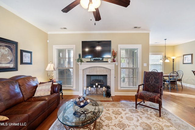 living room with a fireplace, light hardwood / wood-style floors, and ornamental molding