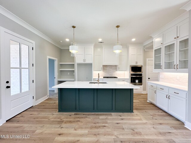 kitchen featuring appliances with stainless steel finishes, white cabinets, and light countertops