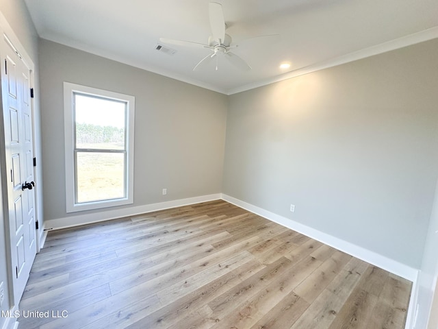 empty room with baseboards, visible vents, a ceiling fan, ornamental molding, and light wood-style floors