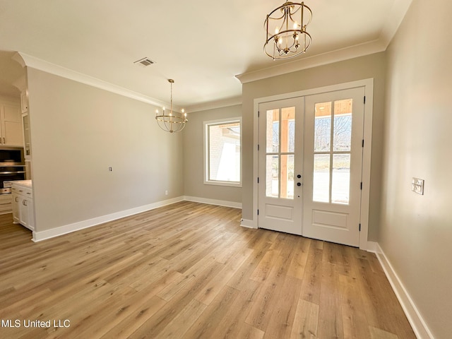 doorway to outside with crown molding, light wood-type flooring, baseboards, and a notable chandelier