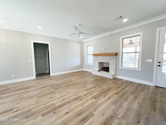 unfurnished living room featuring light wood-style floors, a wealth of natural light, visible vents, and crown molding