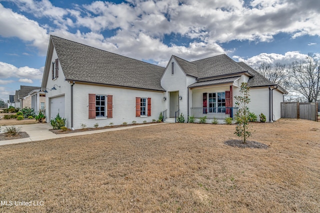 view of front of home featuring a garage, roof with shingles, fence, a porch, and a front yard