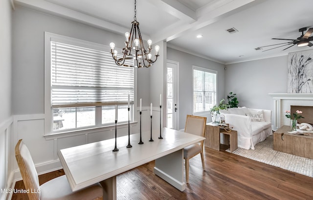 dining area with dark wood-type flooring, a fireplace, visible vents, a ceiling fan, and ornamental molding