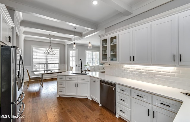 kitchen featuring dark wood finished floors, a sink, stainless steel appliances, white cabinetry, and beam ceiling