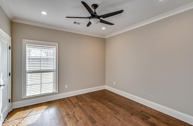 empty room with baseboards, visible vents, a ceiling fan, dark wood-style floors, and ornamental molding