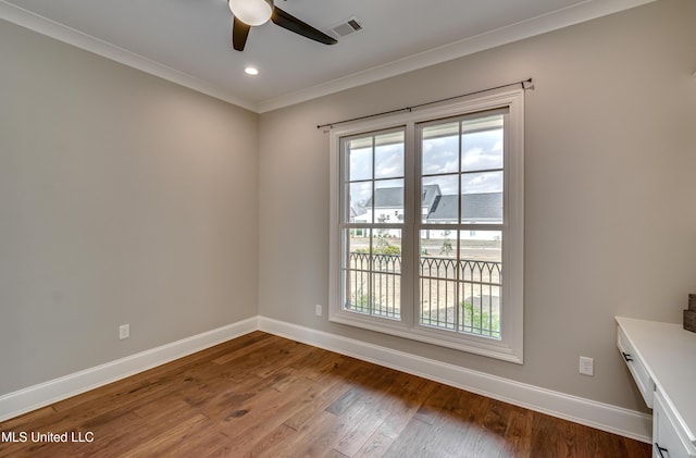 unfurnished room featuring hardwood / wood-style flooring, baseboards, visible vents, and ornamental molding