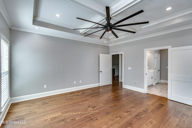 unfurnished bedroom with baseboards, a raised ceiling, ornamental molding, hardwood / wood-style floors, and recessed lighting