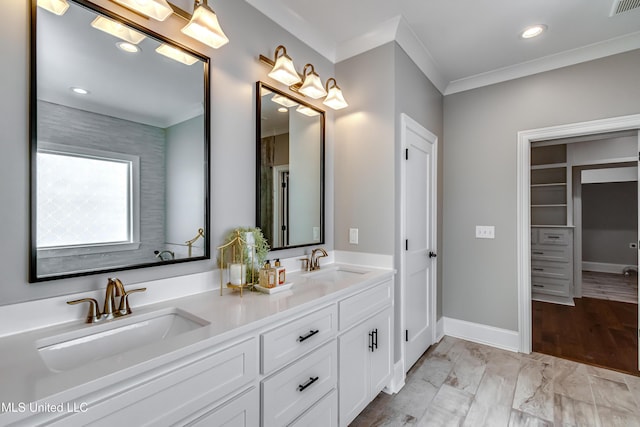 bathroom with ornamental molding, a sink, and baseboards