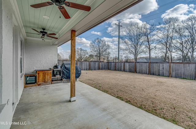 view of patio with grilling area, a fenced backyard, and a ceiling fan