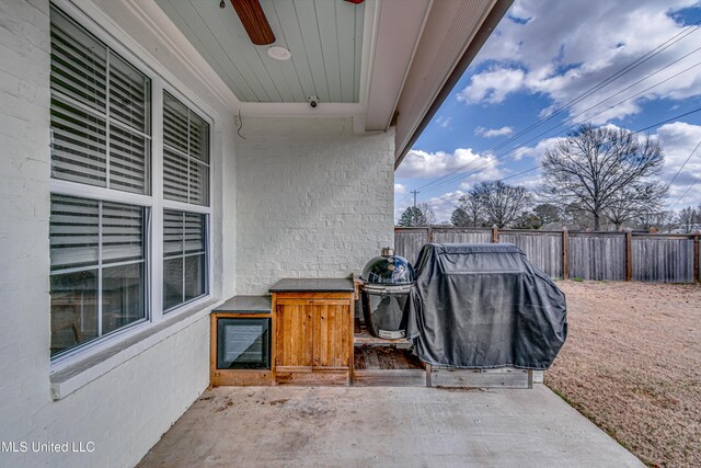 view of patio with a grill and fence