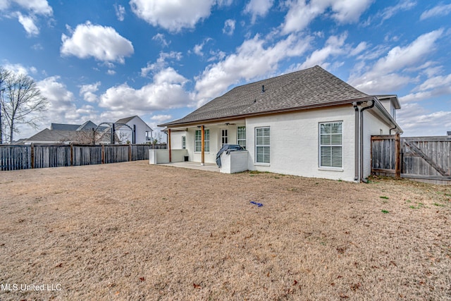 rear view of property featuring a patio area, a fenced backyard, a ceiling fan, and roof with shingles