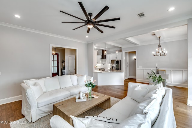 living room with recessed lighting, visible vents, ornamental molding, wood finished floors, and baseboards