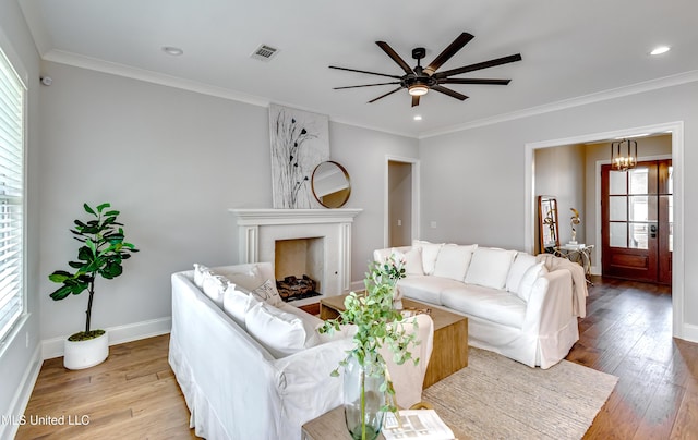 living room with ornamental molding, hardwood / wood-style floors, visible vents, and a healthy amount of sunlight