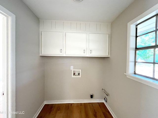 clothes washing area with dark hardwood / wood-style flooring, hookup for an electric dryer, washer hookup, and cabinets