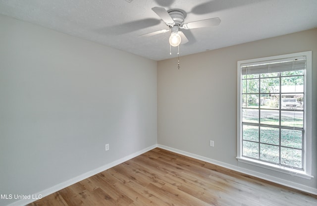 empty room featuring light hardwood / wood-style flooring, a textured ceiling, and ceiling fan