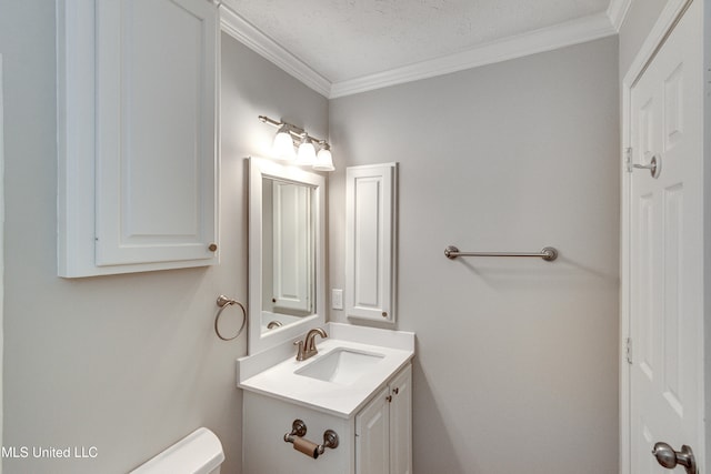 bathroom featuring toilet, ornamental molding, vanity, and a textured ceiling