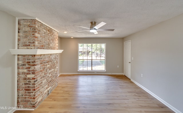 unfurnished living room with ceiling fan, a textured ceiling, and light wood-type flooring