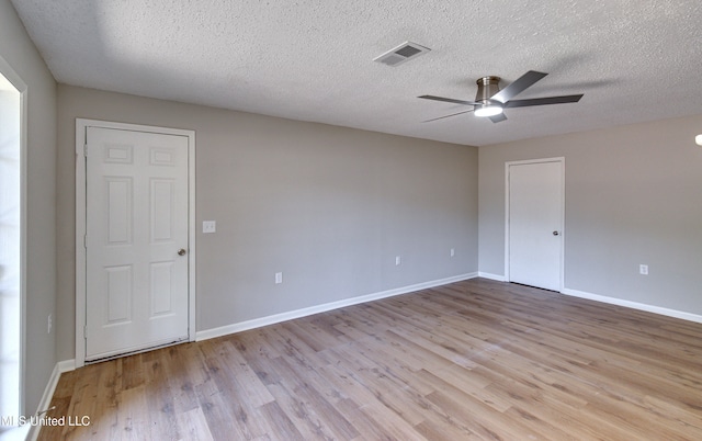 unfurnished room featuring light hardwood / wood-style flooring, a textured ceiling, and ceiling fan