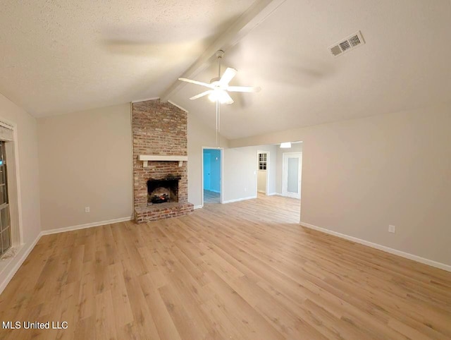 unfurnished living room with ceiling fan, a brick fireplace, light wood-type flooring, and vaulted ceiling with beams