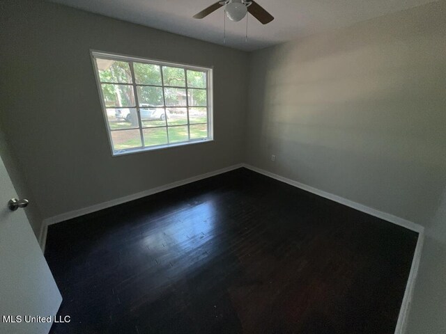 unfurnished room with dark hardwood / wood-style floors and ceiling fan