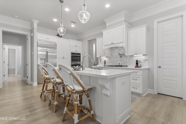 kitchen with white cabinetry, a kitchen breakfast bar, light wood-style floors, light countertops, and appliances with stainless steel finishes