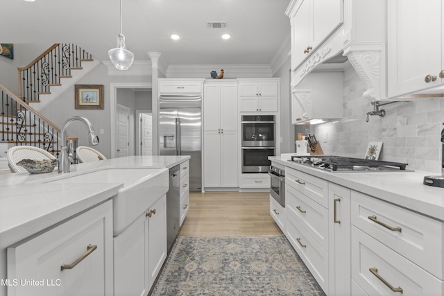 kitchen with visible vents, appliances with stainless steel finishes, white cabinets, and a sink