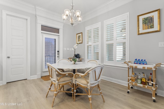 dining space featuring ornamental molding, a chandelier, light wood-style flooring, and baseboards