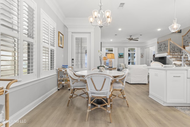 dining room featuring visible vents, baseboards, light wood-style flooring, stairway, and ornamental molding