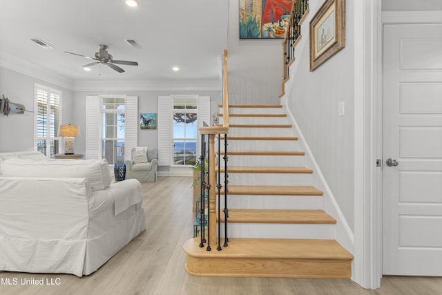 stairs featuring ornamental molding, wood finished floors, and visible vents