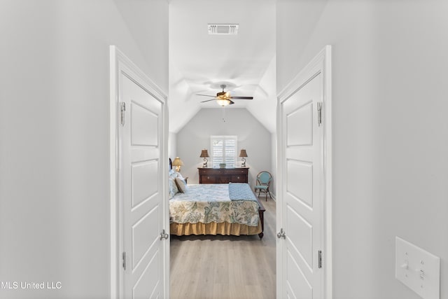 bedroom featuring lofted ceiling, visible vents, ceiling fan, and light wood finished floors