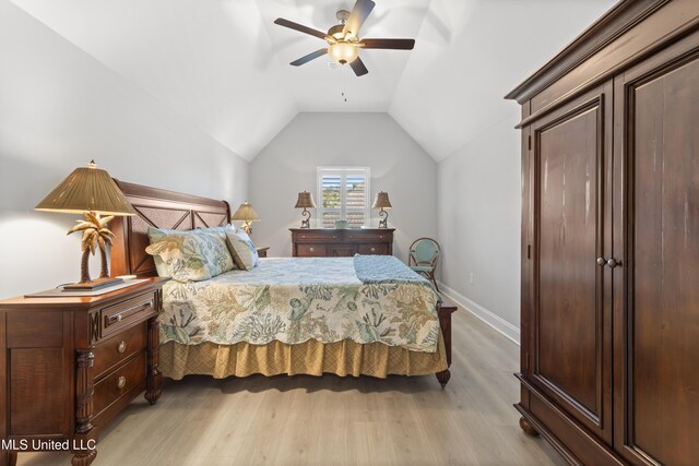 bedroom with lofted ceiling, light wood finished floors, baseboards, and a ceiling fan