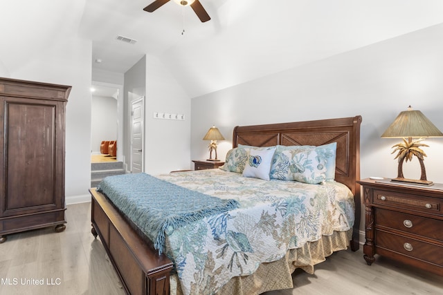 bedroom featuring lofted ceiling, light wood-style floors, visible vents, and a ceiling fan