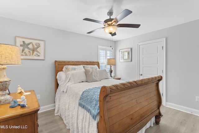 bedroom with light wood-style flooring, baseboards, and ceiling fan