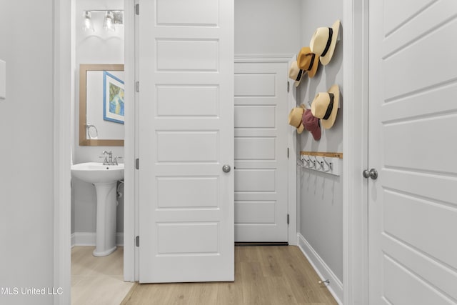 bathroom featuring a sink, baseboards, and wood finished floors