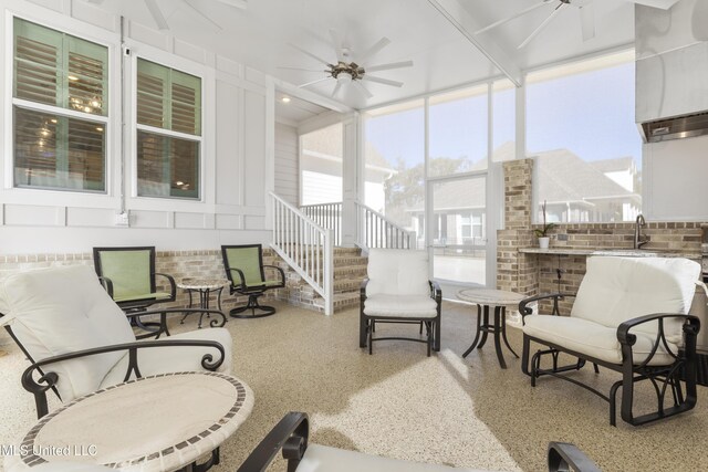 sunroom / solarium featuring a ceiling fan and a sink