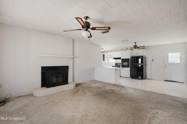 unfurnished living room featuring light carpet, ceiling fan, and a brick fireplace