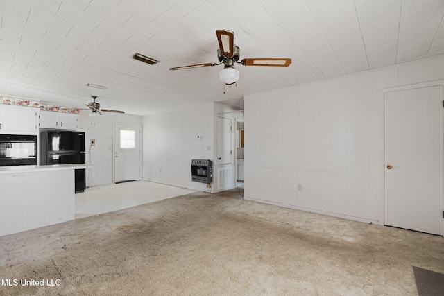 unfurnished living room with light carpet, heating unit, and ceiling fan