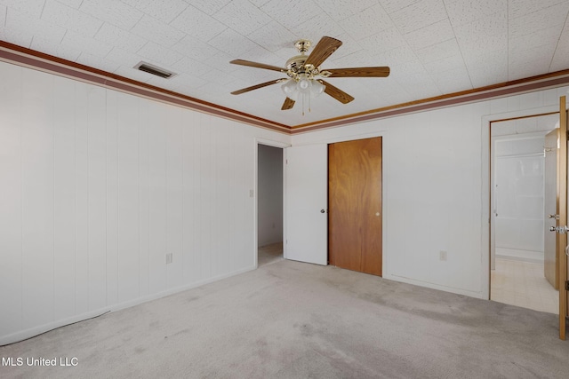 spare room with ceiling fan, light colored carpet, and ornamental molding