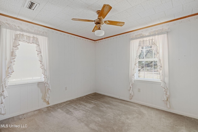 unfurnished room with ceiling fan, light colored carpet, and ornamental molding