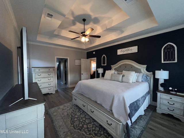 bedroom featuring dark hardwood / wood-style floors, a raised ceiling, ceiling fan, and crown molding