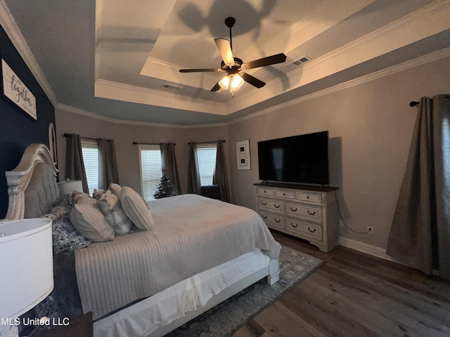 bedroom with a tray ceiling, multiple windows, ceiling fan, and dark hardwood / wood-style floors