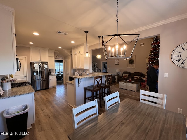 dining area featuring dark hardwood / wood-style floors, crown molding, and an inviting chandelier