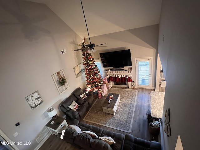 living room with hardwood / wood-style floors, ceiling fan, and high vaulted ceiling