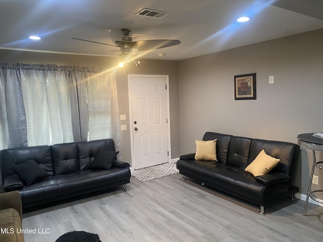 living room featuring light hardwood / wood-style floors and ceiling fan