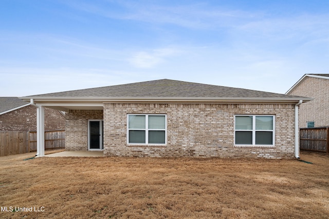 rear view of property featuring a yard and a patio area