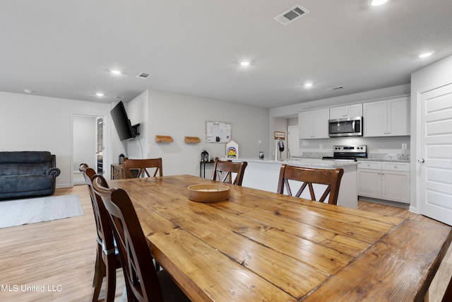 dining room with sink and light hardwood / wood-style flooring